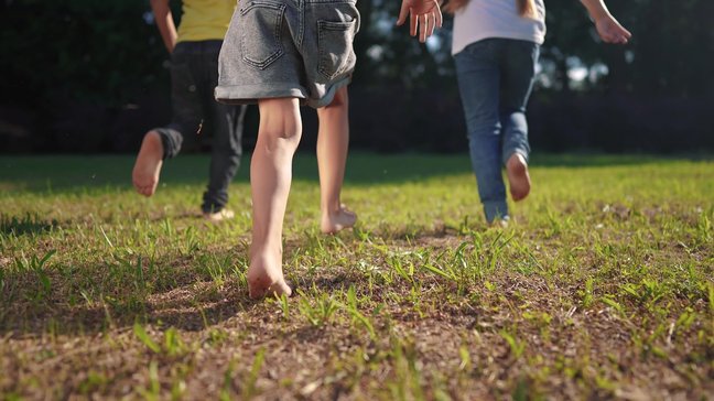 Orthopädiezentrum Wien - Kinder laufen barfuß im Freien. 