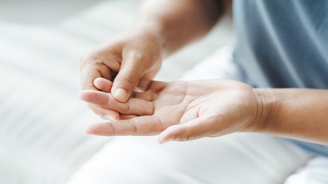 Orthopädiezentrum Wien - Schnappfinger bei einer Person, die ihren Finger hält