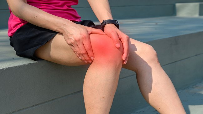 Orthopädiezentrum Wien - Tractussyndrom bei einer Person, die ihr Knie hält